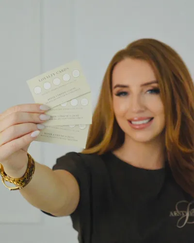 Jessica holding Aesthetica's loyalty cards